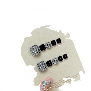 Elegant black press-on toe nails with rhinestones on a white display card