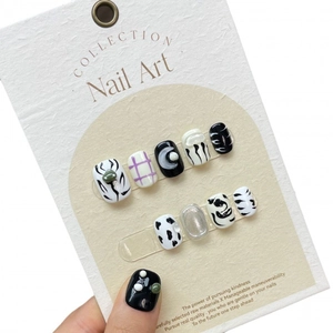 Handmade black and white anime style press-on nails with minimalist patterns on card