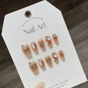 Faux ongles faits main dégradé caramel avec cœurs dorés 3D et strass brillants