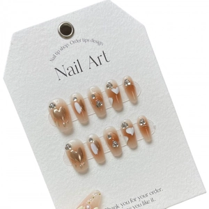 Faux ongles faits main avec cœurs, dégradé ambre caramel et relief doré élégant