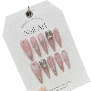 Pink cat-eye press-on nails with butterfly pattern and crystal accents in long almond shape