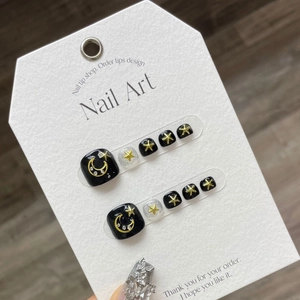 Star and moon motif black and silver glitter press-on toe nails on a white card display