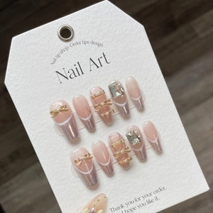 Pink ballet press-on nails with silver French tips, pearls, and golden 3D bows