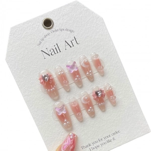 Handmade press-on nails in light pink with 3D heart rhinestones and butterfly charms