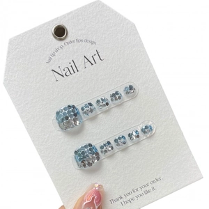 Handmade press-on toenails featuring sparkling blue and silver sequins on white display card