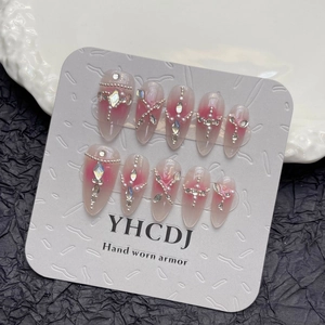 Handmade almond press-on nails with pink blush gradient and sparkling rhinestone accents