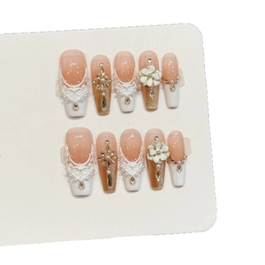 Elegant orange lace press-on nails with white 3D flowers, pearls, and rhinestones