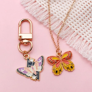 Enamel butterfly jewelry set featuring rose gold pendant necklace and matching keychain