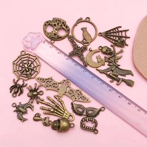 Detailed view of bronze Halloween charms including spider webs and skulls for DIY jewelry