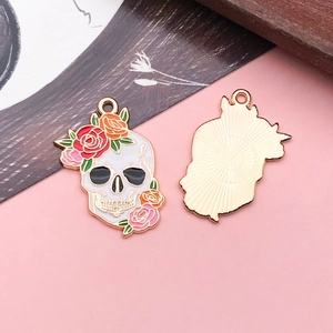 Front and back detail of gold enamel skull charm with colorful rose flowers for DIY jewelry