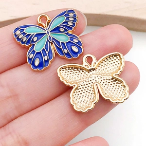 Detailed macro view of colorful butterfly charm showing vibrant blue enamel and golden back