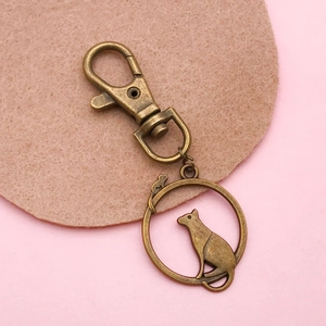 Antique bronze keychain with lobster clasp and circular hollow cat silhouette pendant