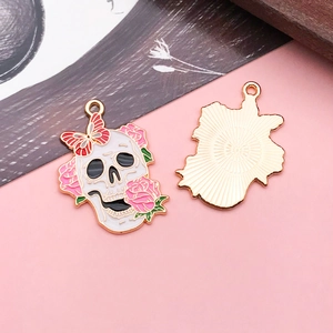Detail of skull pendant with red roses and butterfly for DIY jewelry making