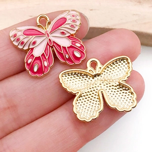 Detail of colorful enamel butterfly charm showing front and textured gold-plated back side