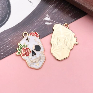 Detailed macro of Day of the Dead skull charms with rose pattern and enamel finish