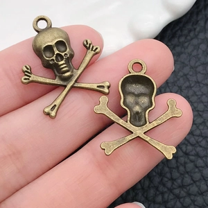 Macro view of bronze skull and crossbones metal charms for DIY jewelry crafting