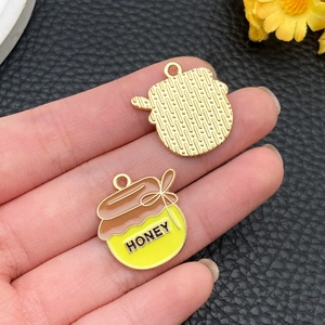 Gedetailleerd voor- en achteraanzicht van kleine honingpotbedeltjes voor sieraden