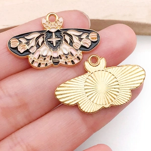 Macro shot showing front and back details of enamel butterfly charms with gold finish