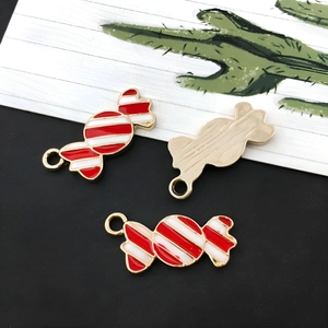 Detail van rood-wit gestreepte emaille snoepbedeltjes met gouden randen voor DIY-sieraden