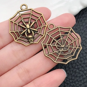 Detail of vintage bronze spider web and skull charms for Halloween DIY jewelry making