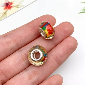 Makro-Detail von farbenfrohen Harzperlen mit Facettenschliff und Metallkern für Armbänder