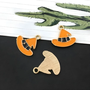 Detail van emaille toenaarshoed hanger met oranje druppelolie en gouden metalen achterkant
