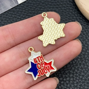 Close-up of star-shaped July 4th enamel pendant held by hand to show size and texture