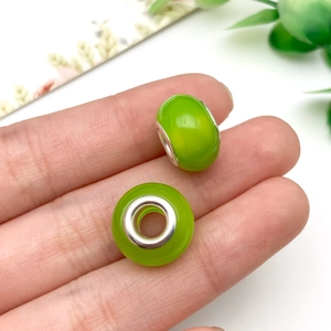 Primer plano de cuentas de resina verde tallada con núcleo de plata para joyas DIY