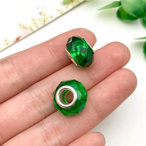 Primer plano de cuentas facetadas verde esmeralda con núcleo de metal para joyas DIY