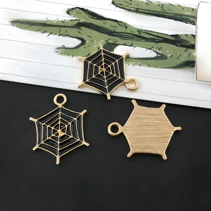 Macro-detail van drie spinnenweb-hangers van legering met zwart email en goud