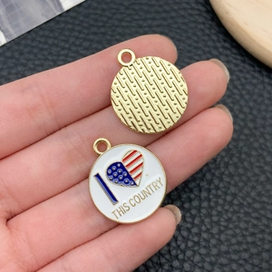 Detail of round enamel American flag heart charms with textured alloy metal back