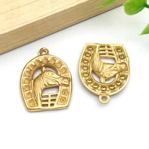 Macro detail of golden horseshoe and horse head charms with polished metal finish