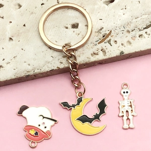 Halloween keychain with golden ring featuring ghost, moon, and skeleton charms