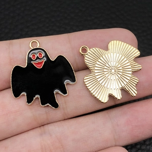 Detailed view of Halloween ghost charms with black enamel finish and gold textured backing