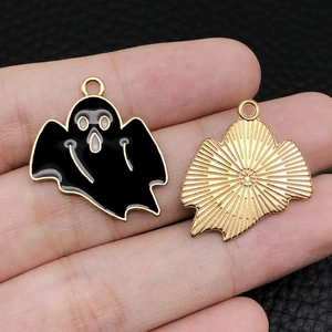 Detailed macro view showing the front and back of a ghost charm with black enamel and gold metal