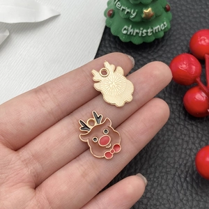 Detail von Weihnachts-Rentier-Emaille-Anhängern in Goldoptik für DIY-Schmuck in der Hand
