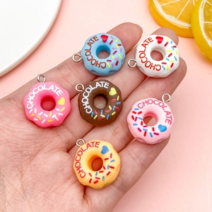 Set of 6 colorful resin donut pendants with chocolate text and heart patterns in hand