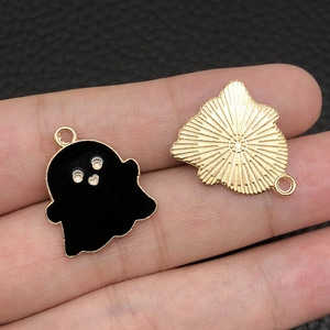 Detail of Halloween ghost charms with black enamel finish and golden textured back