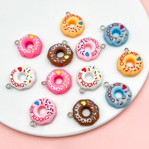 Macro view of colorful resin donut charms with chocolate lettering and metal loops