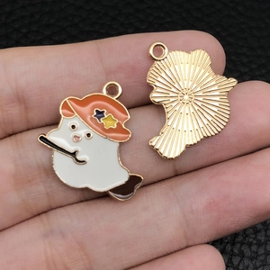 Macro shot of ghost charm with orange star witch hat and gold sunburst pattern back