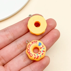 Macro view of realistic resin donut charms with chocolate text and colorful sprinkles