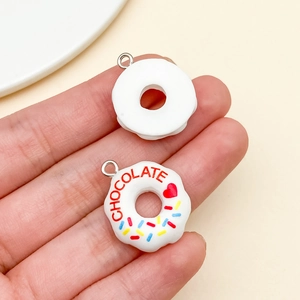 Macro view of 3D resin donut pendants with chocolate text and colorful sprinkles