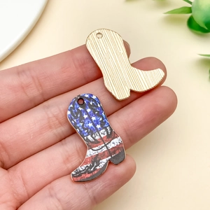 Detailed macro of gold-plated cowboy boot pendants with American flag patterns