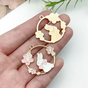 Dettaglio del ciondolo a coniglio fai-da-te con design cavo dorato e smalto rosa