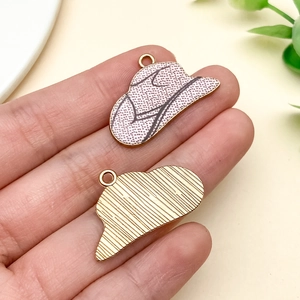 Detail of pink hat charms with dots showing gold-plated alloy back texture for DIY jewelry
