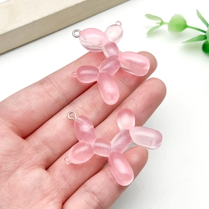 Dettaglio del ciondolo a forma di cane palloncino in resina rosa per gioielli fai-da-te