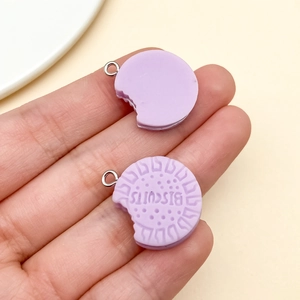Detail of purple resin biscuit charms with metal rings for DIY jewelry and keychain decor