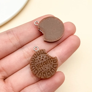 Macro view of resin sandwich biscuit pendants showing texture and bite mark detail