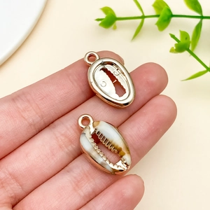 Macro shot of seashell pendants with gold plated edges for DIY jewelry making accessories