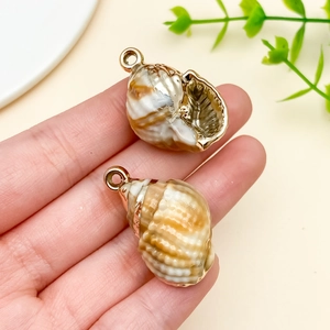 Detail of laser-plated acrylic shell pendant with gold edges for DIY jewelry making